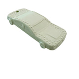 A pale mint green car-shaped silicone teether with raised stud details around the edges, resting on a white marble-patterned surface.