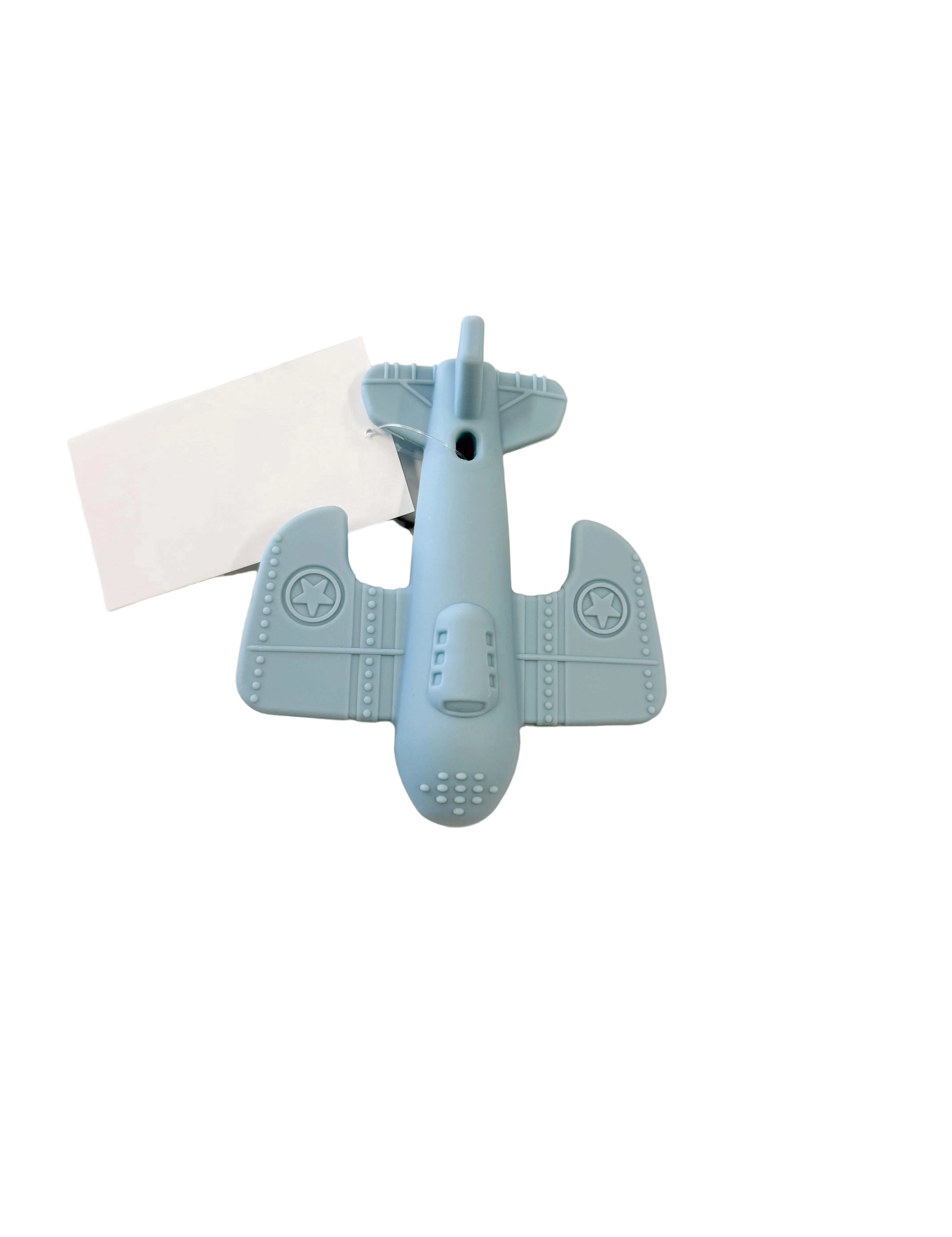 A light blue airplane-shaped silicone lip balm tube lying on a white marble surface next to a blank white card.