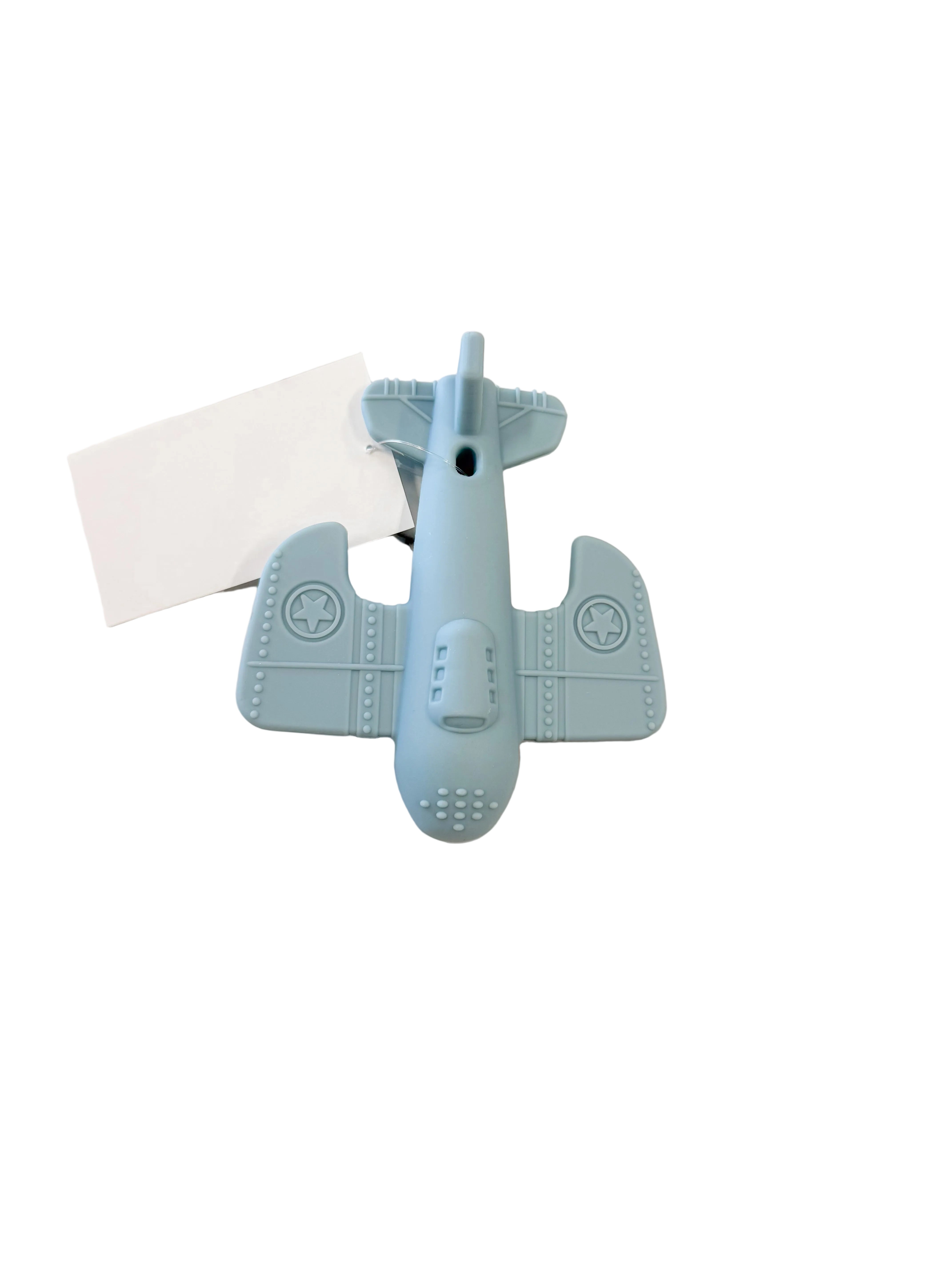 A light blue airplane-shaped silicone lip balm tube lying on a white marble surface next to a blank white card.