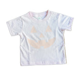 pink t-shirt with a beige abstract design on a wooden surface