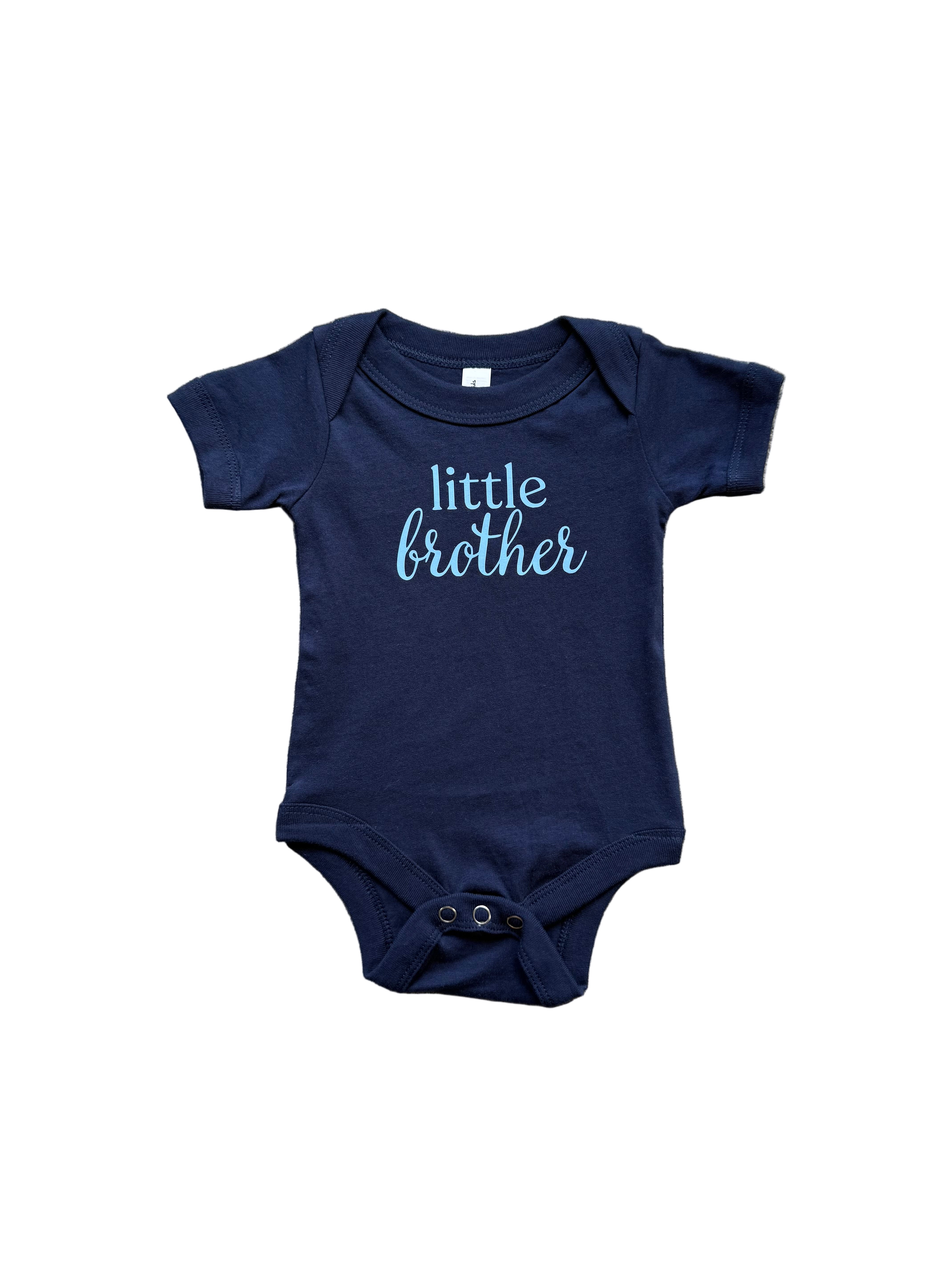 Navy blue baby onesie with 'little brother' text on a textured surface