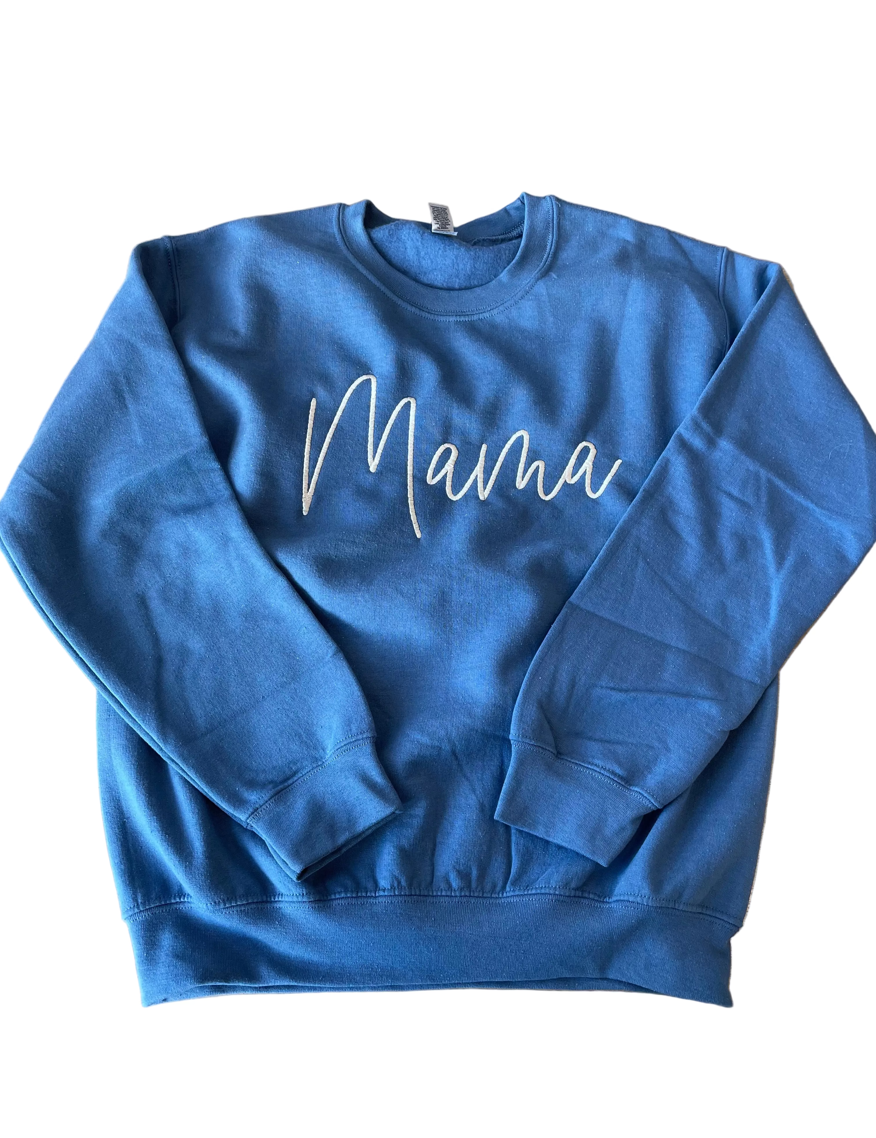 Blue sweatshirt with 'Mama' text on a wooden surface