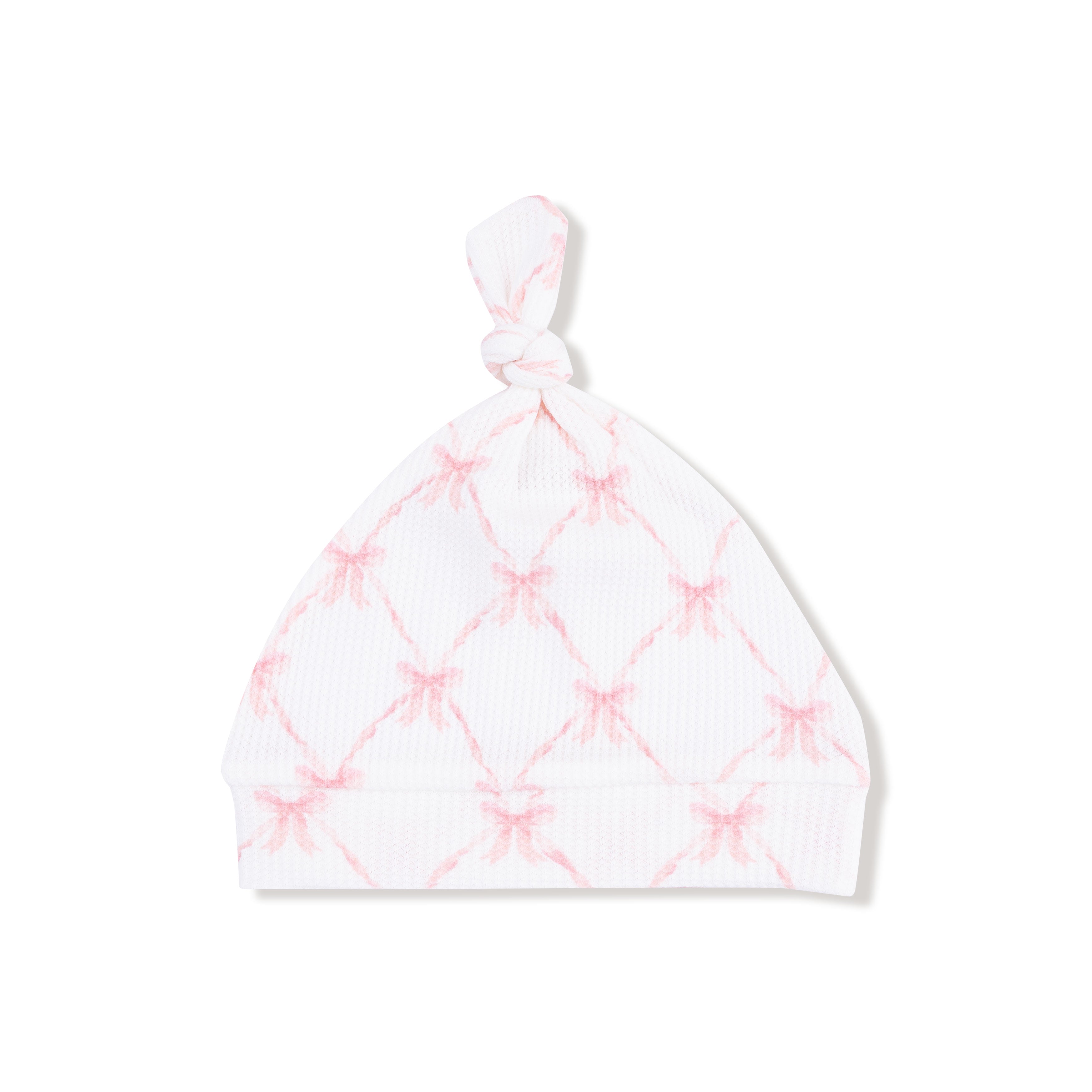 White baby hat with pink diamond pattern on a white background