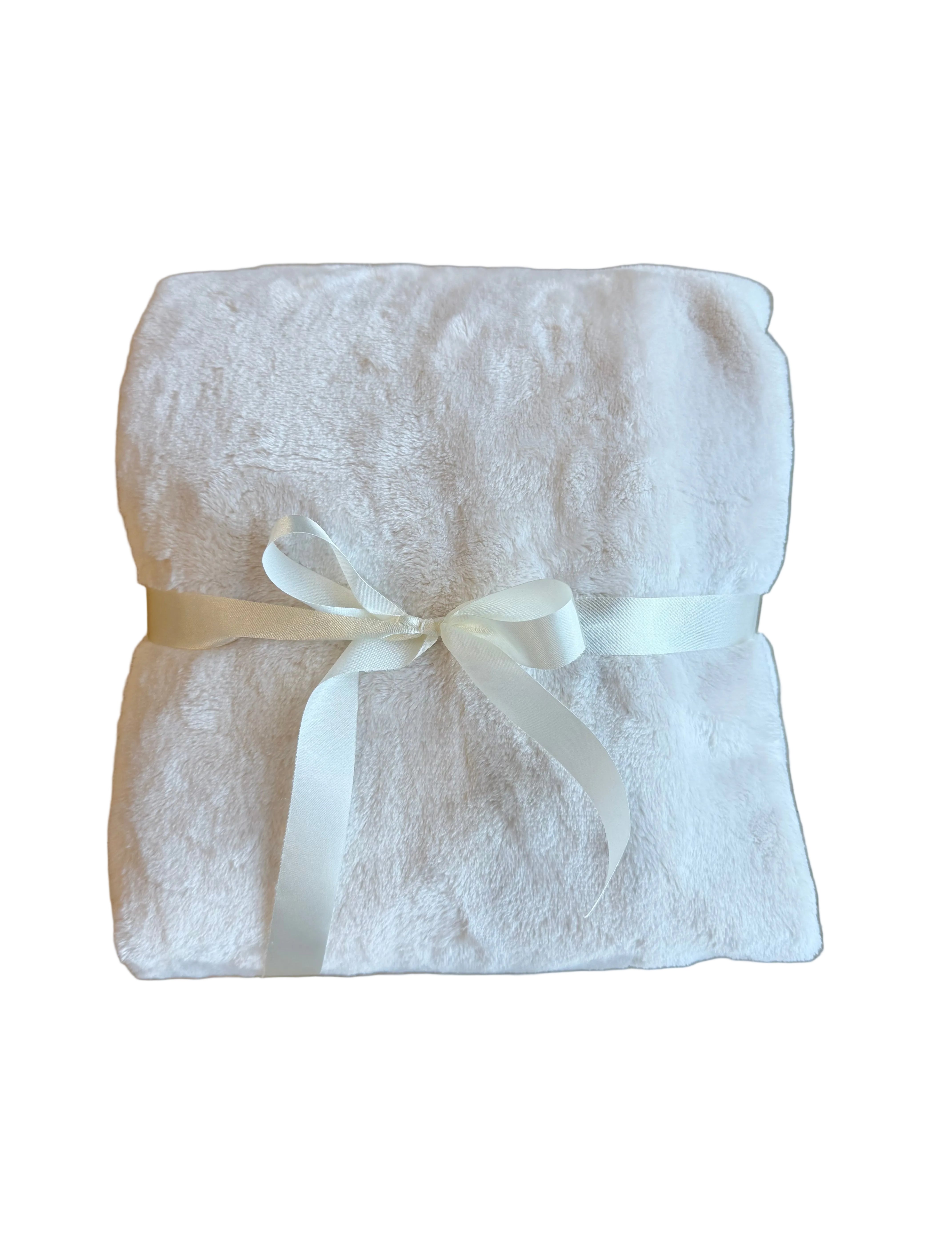 Folded white towel with a ribbon on a wooden surface