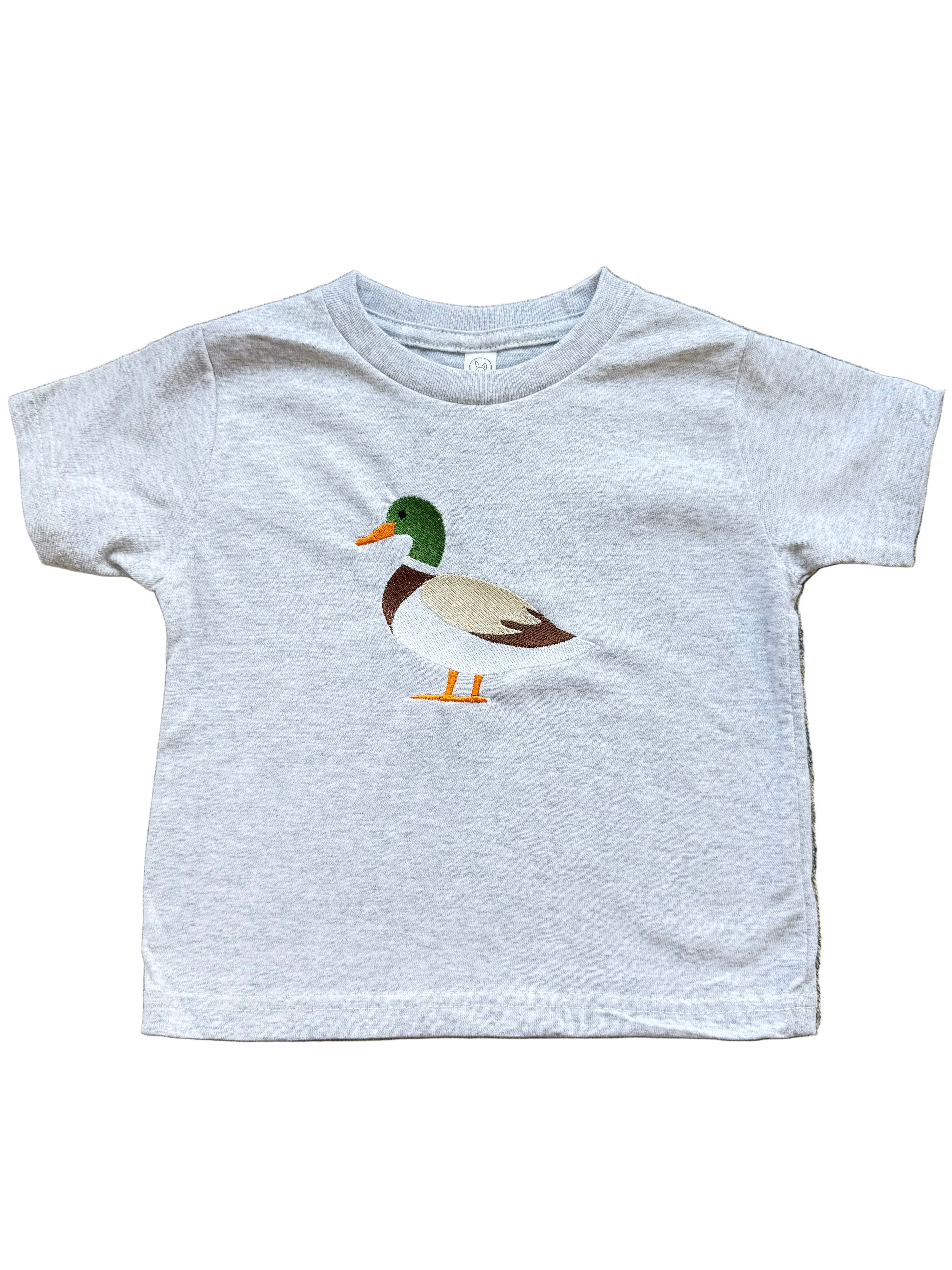 Gray t-shirt with a duck graphic on a textured surface