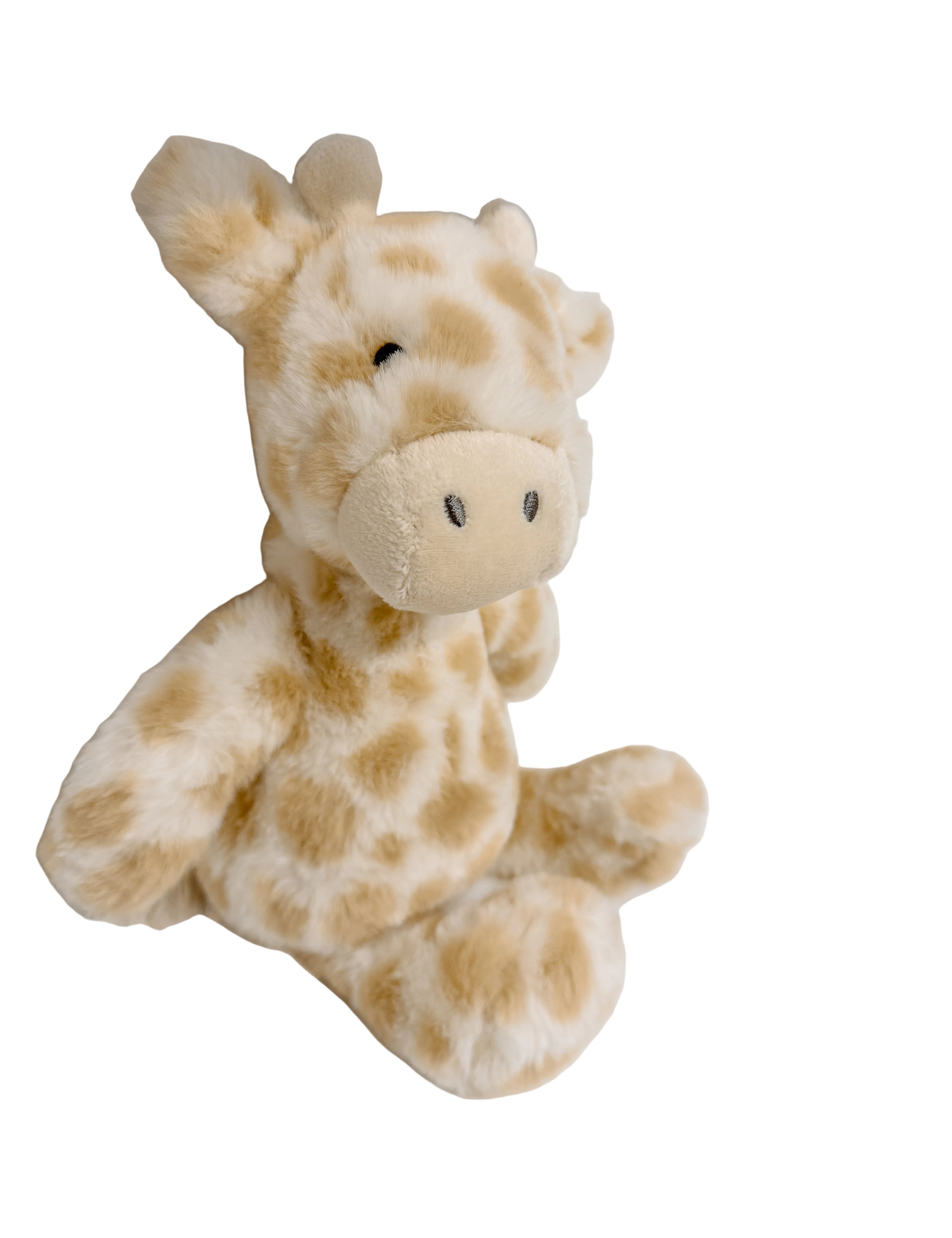 Plush giraffe toy on a white surface with a blurred background