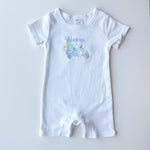 A white short-sleeve baby romper with a small light blue and green golf cart graphic on the chest, laid flat on a light gray background.