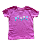 Pink t-shirt with floral design on a wooden floor