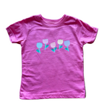 Pink t-shirt with floral design on a wooden floor