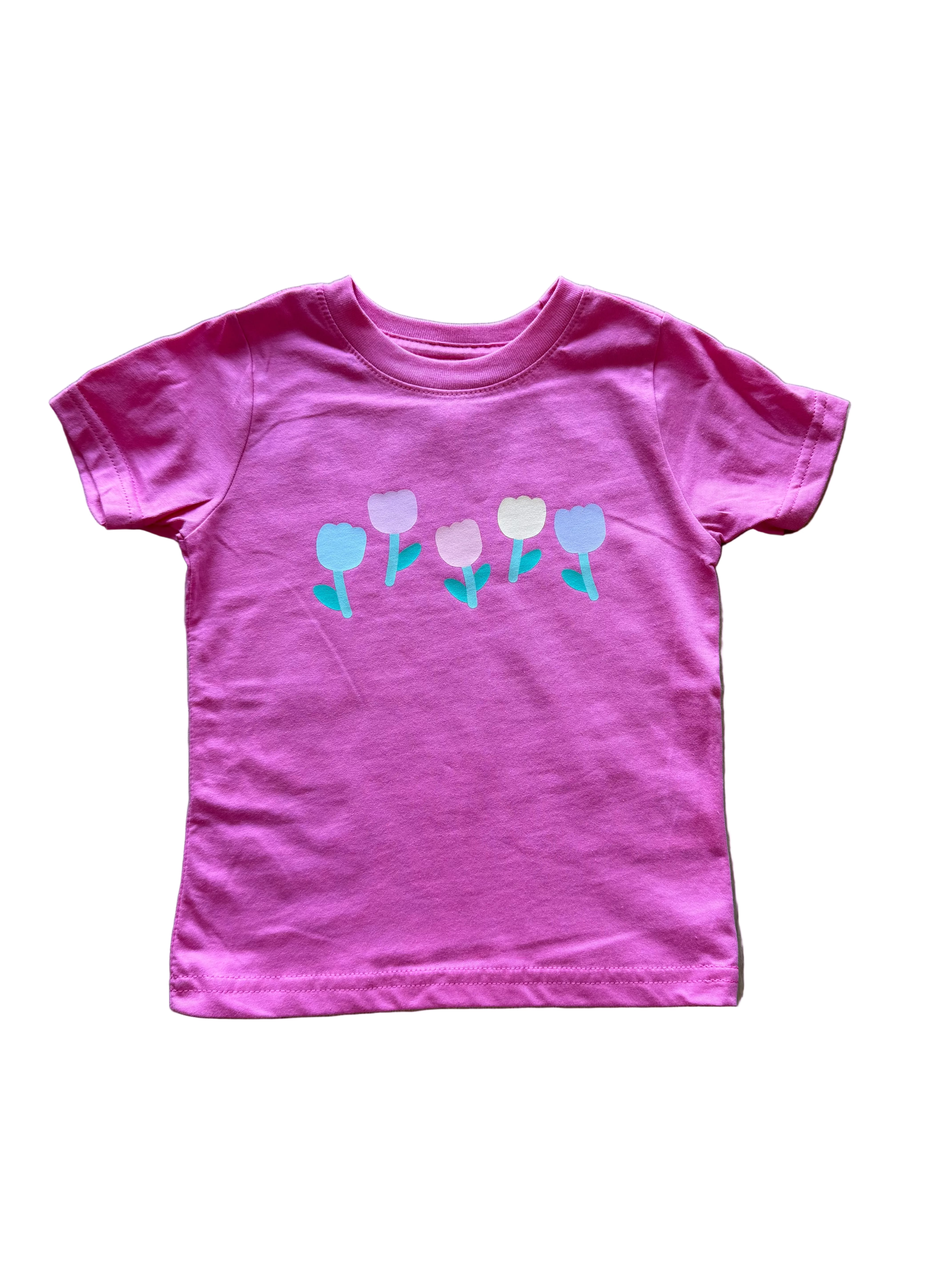 Pink t-shirt with floral design on a wooden floor