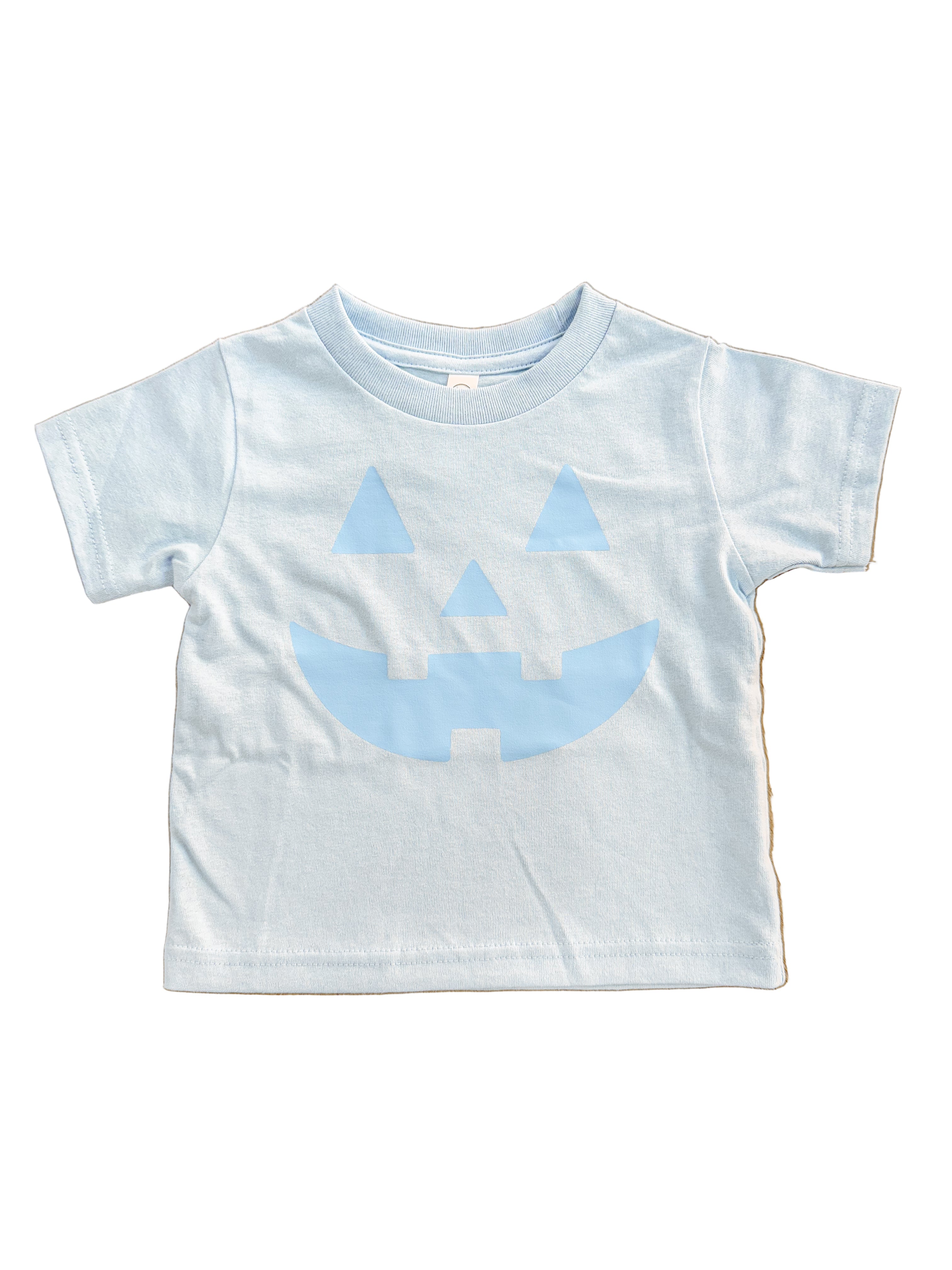 light blue kids  t-shirt with blue jack-o'-lantern design on a wooden floor