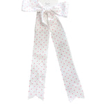 Polka dot ribbon tied in a bow on a marble surface