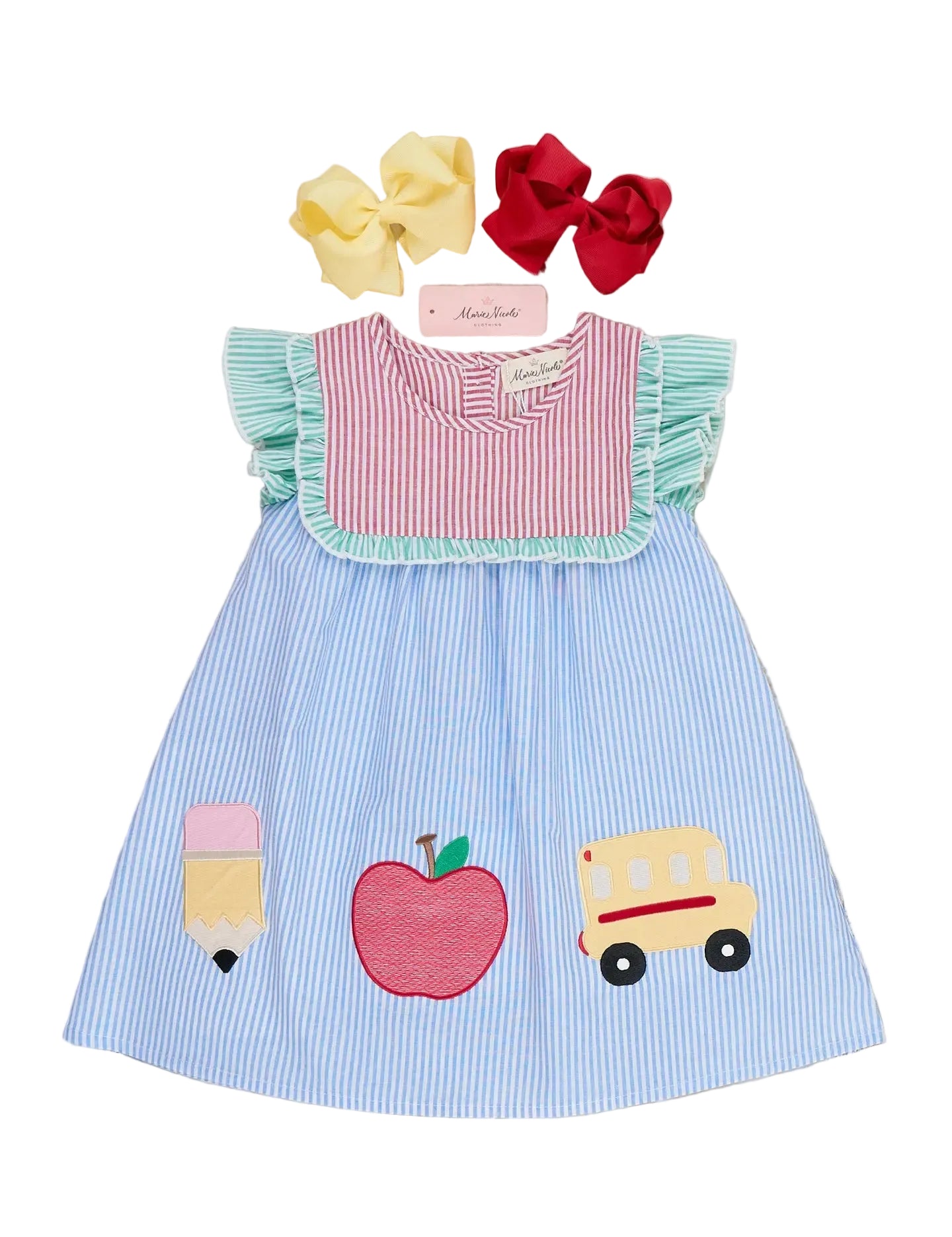 Children's dress with appliqués of a school bus, apple, and ice cream cone on a wooden surface.