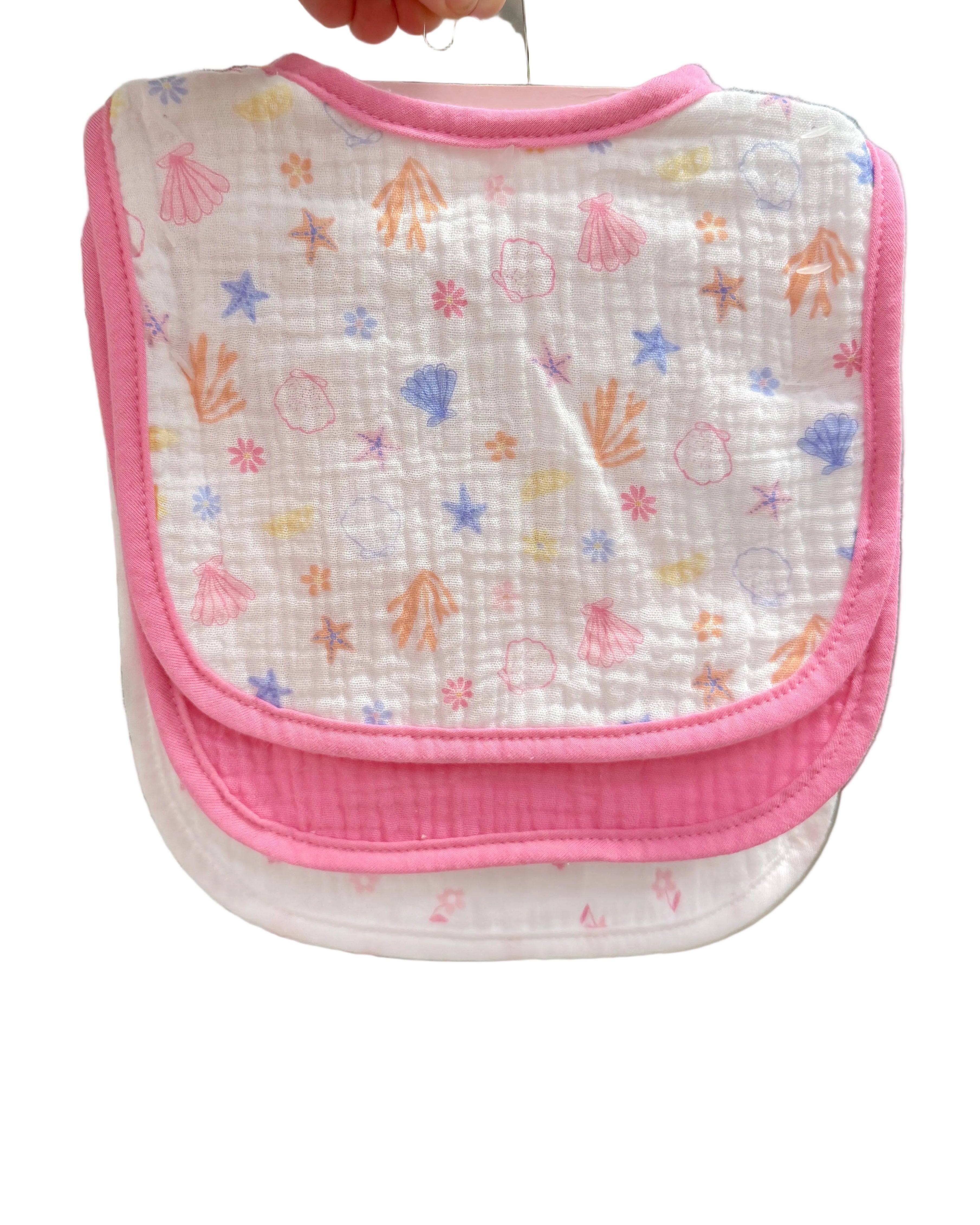 Baby bib with colorful patterns held up in a store setting