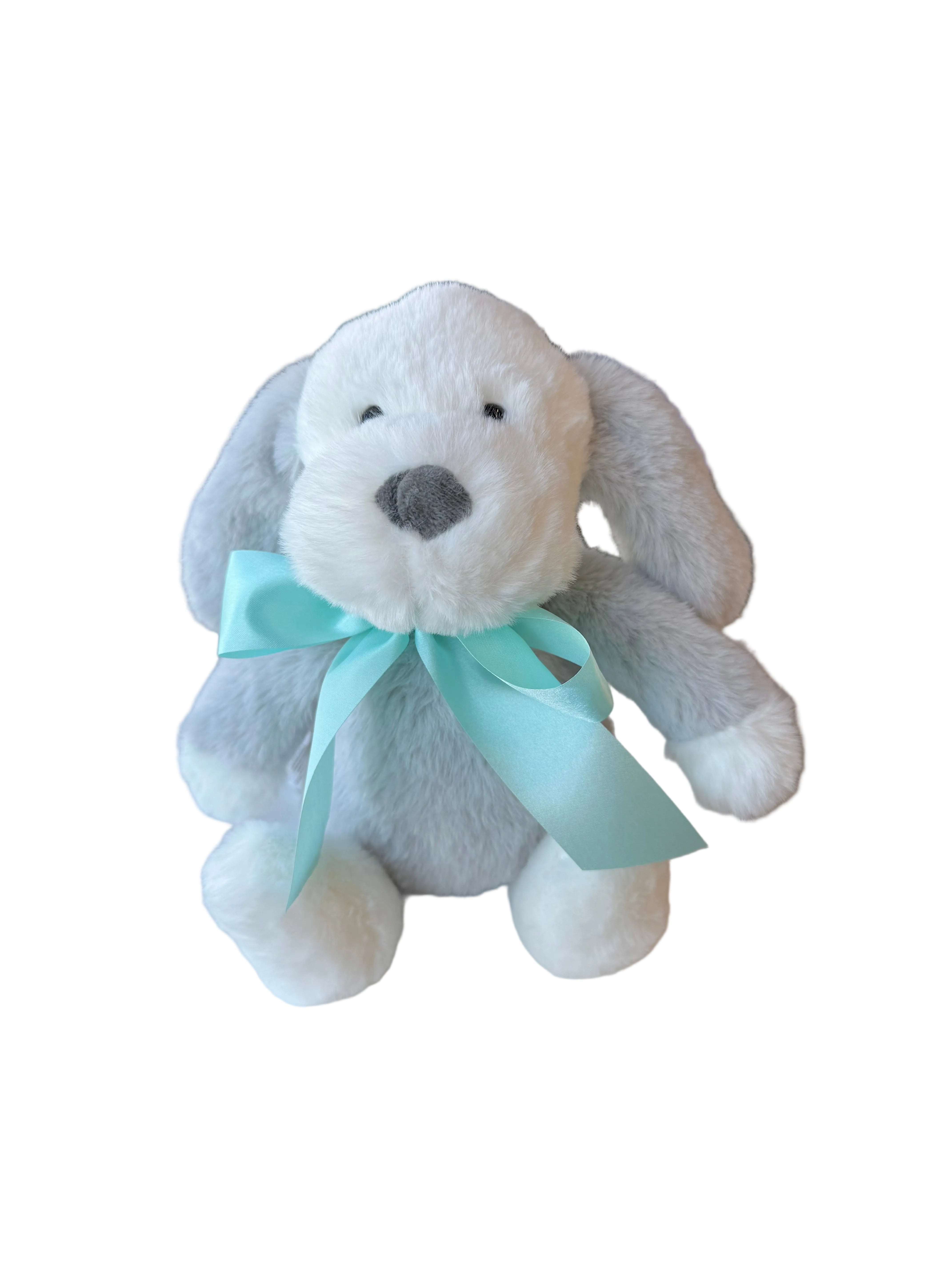 Plush dog toy with a blue bow on a white surface in a store setting